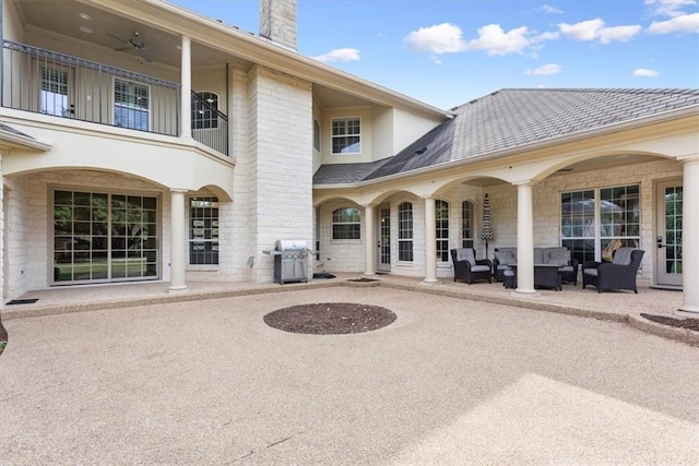 back of house featuring ceiling fan, an outdoor living space, and a patio