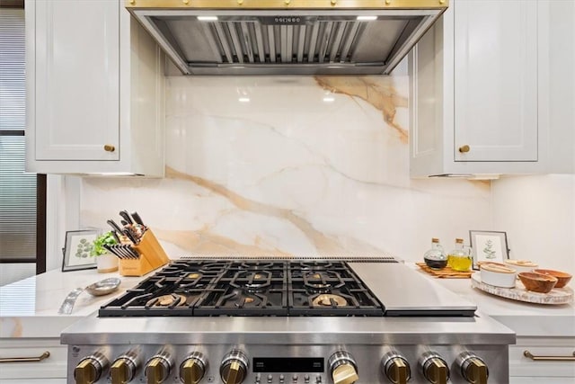 kitchen with white cabinetry, backsplash, range, and custom range hood