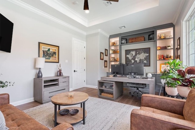 office area featuring ceiling fan, hardwood / wood-style floors, built in features, and a raised ceiling