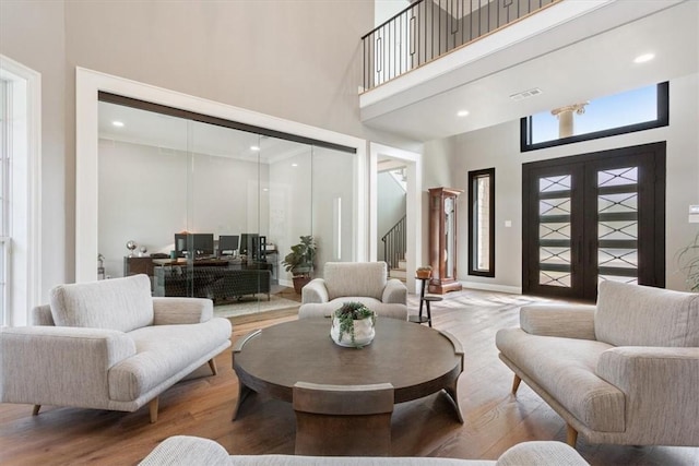 living room featuring a high ceiling, hardwood / wood-style floors, and french doors