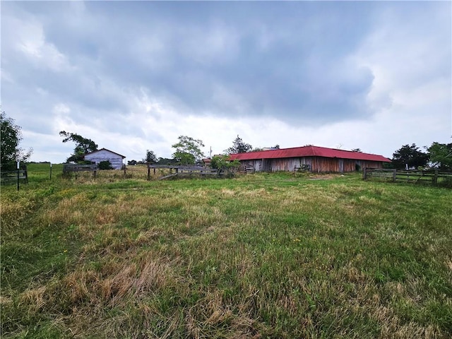 view of yard with a rural view and an outdoor structure