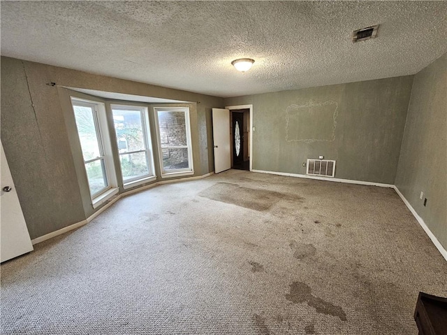 unfurnished room featuring carpet flooring and a textured ceiling