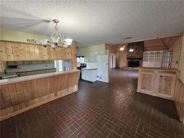 kitchen with stainless steel range, a notable chandelier, and wood walls