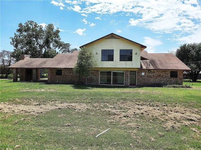 rear view of property featuring a lawn