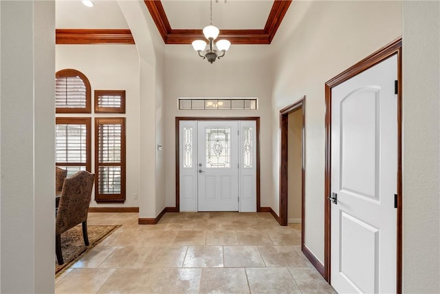 foyer entrance with a high ceiling, crown molding, plenty of natural light, and a notable chandelier