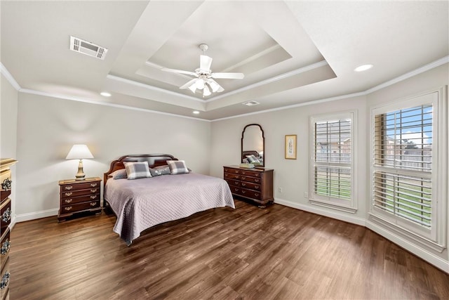 bedroom featuring ceiling fan, ornamental molding, dark hardwood / wood-style flooring, and a tray ceiling