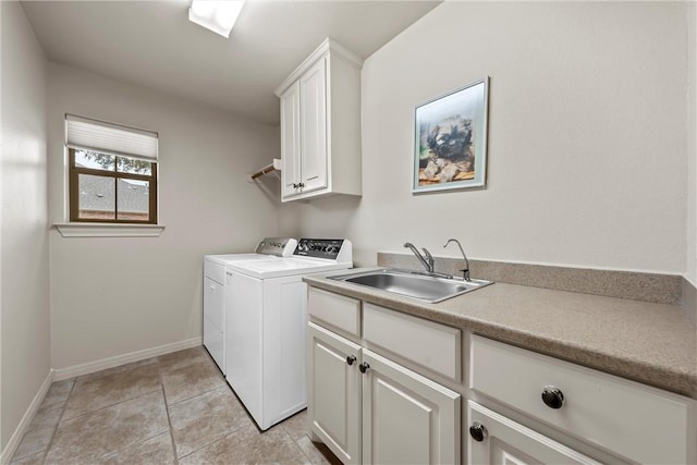 laundry room featuring washing machine and dryer, light tile patterned flooring, sink, and cabinets