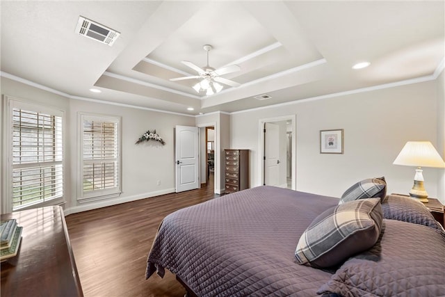 bedroom featuring ceiling fan, dark hardwood / wood-style flooring, a tray ceiling, and ornamental molding