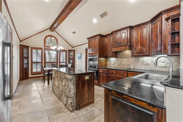 kitchen featuring backsplash, a kitchen island, vaulted ceiling with beams, sink, and appliances with stainless steel finishes