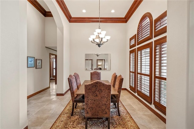 dining room with a high ceiling, crown molding, and a chandelier