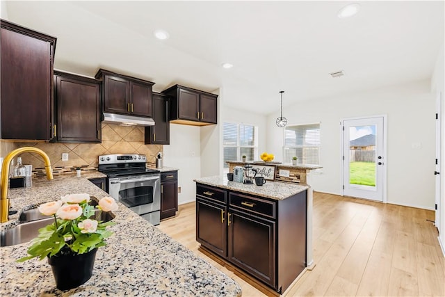 kitchen with light stone countertops, sink, hanging light fixtures, decorative backsplash, and stainless steel range with electric cooktop