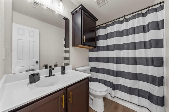 bathroom featuring toilet, vanity, and hardwood / wood-style flooring