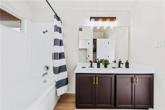 bathroom with hardwood / wood-style floors, vanity, and shower / bathtub combination with curtain