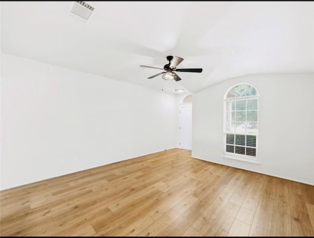 spare room featuring hardwood / wood-style flooring and lofted ceiling