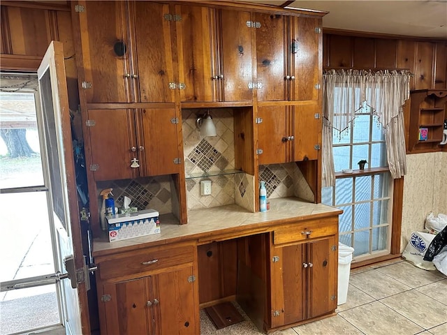 kitchen with tasteful backsplash, a healthy amount of sunlight, and light tile patterned flooring