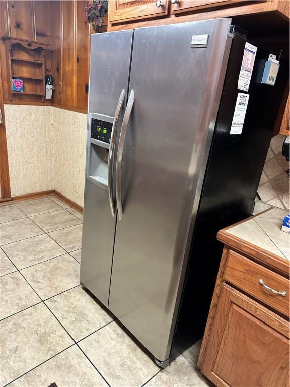 kitchen featuring tile countertops, stainless steel fridge with ice dispenser, and light tile patterned floors