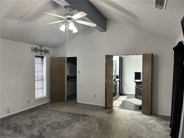 unfurnished bedroom featuring connected bathroom, ceiling fan, carpet floors, a textured ceiling, and lofted ceiling