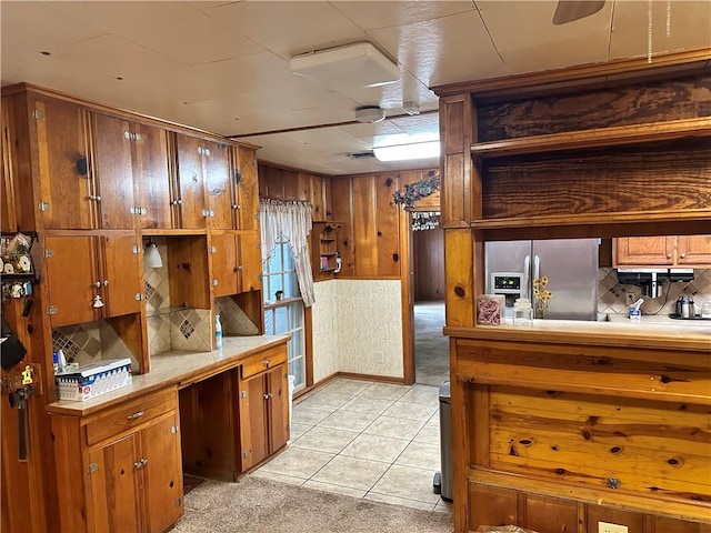 kitchen featuring light tile patterned flooring, stainless steel fridge with ice dispenser, and backsplash