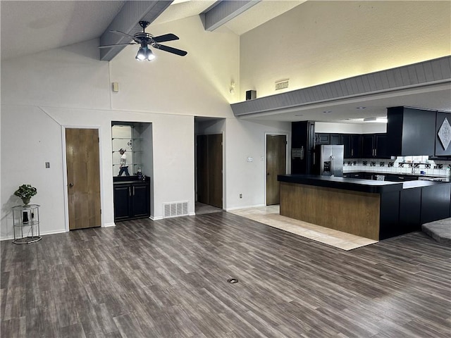 kitchen with ceiling fan, beam ceiling, hardwood / wood-style flooring, high vaulted ceiling, and stainless steel fridge with ice dispenser