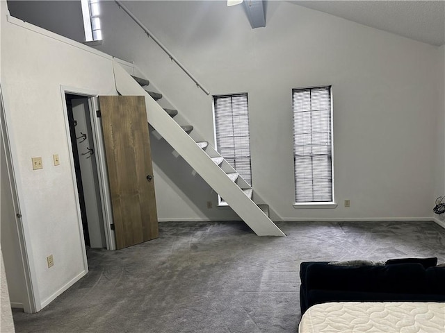 carpeted living room with ceiling fan and high vaulted ceiling