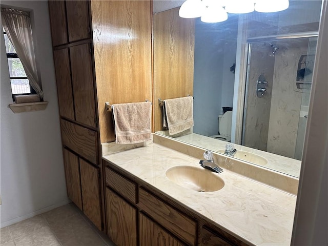 bathroom with tile patterned floors, vanity, toilet, and a shower with door