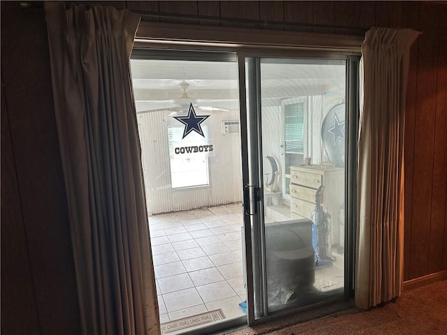 doorway to outside featuring wood walls and light tile patterned floors