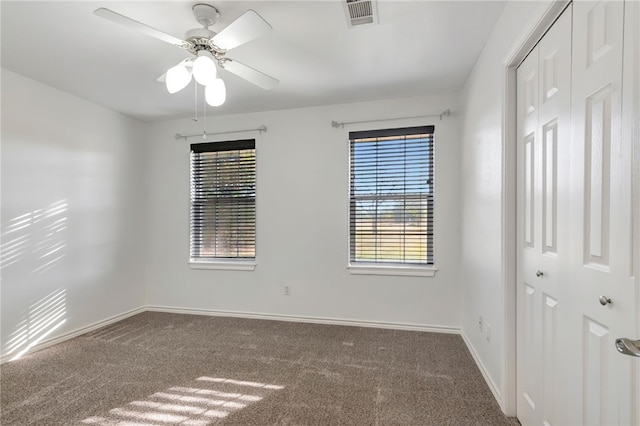 carpeted spare room with ceiling fan