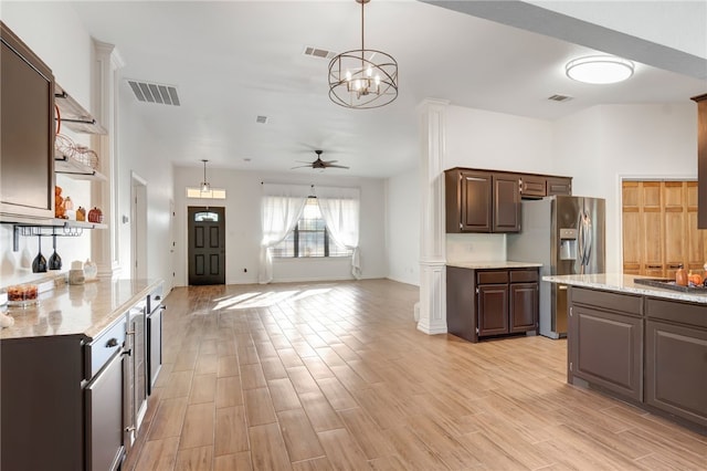 kitchen featuring ceiling fan with notable chandelier, dark brown cabinetry, light hardwood / wood-style floors, and hanging light fixtures