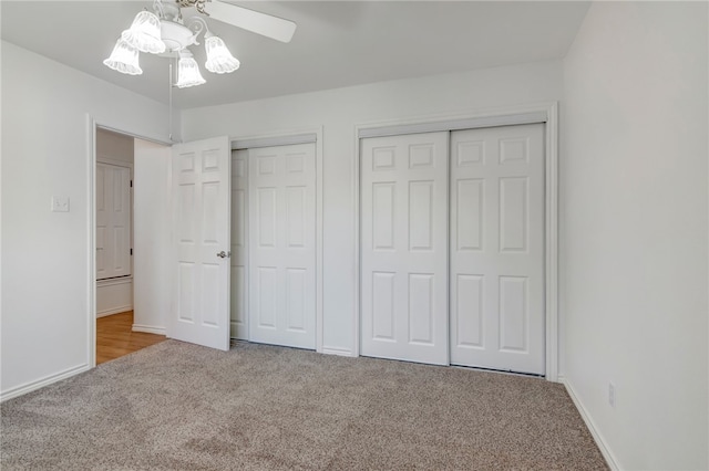 unfurnished bedroom with carpet flooring, ceiling fan, and multiple closets