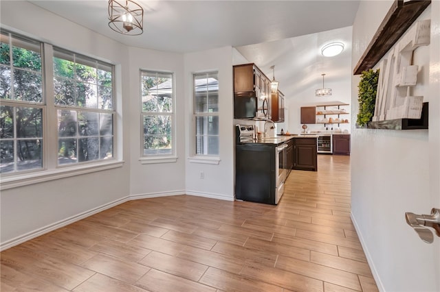 kitchen featuring vaulted ceiling, electric range, light hardwood / wood-style flooring, dark brown cabinetry, and a chandelier