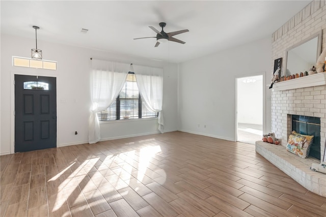 unfurnished living room featuring ceiling fan, a fireplace, and light hardwood / wood-style floors