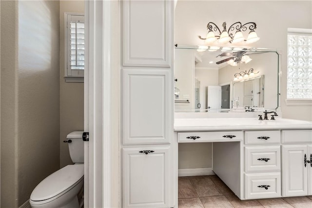 bathroom with vanity, toilet, plenty of natural light, and ceiling fan