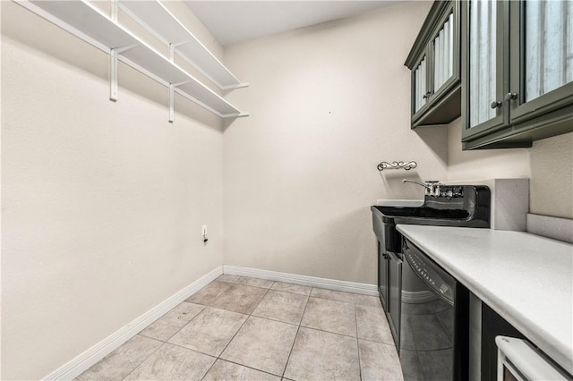 laundry area with cabinets, sink, and light tile patterned flooring