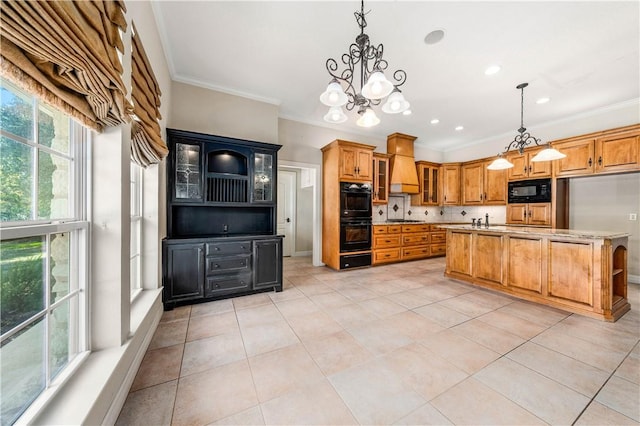 kitchen with pendant lighting, premium range hood, an inviting chandelier, and black appliances