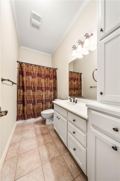 bathroom with tile patterned flooring, vanity, toilet, and ornamental molding