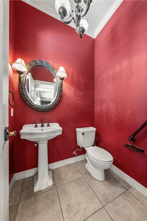 bathroom featuring crown molding, tile patterned flooring, and toilet