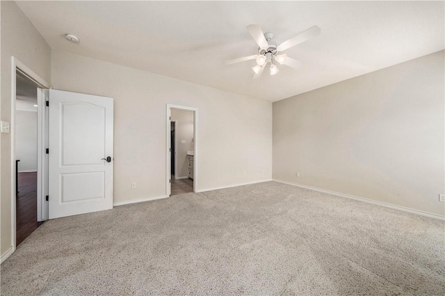 unfurnished bedroom featuring carpet flooring, ensuite bath, and ceiling fan