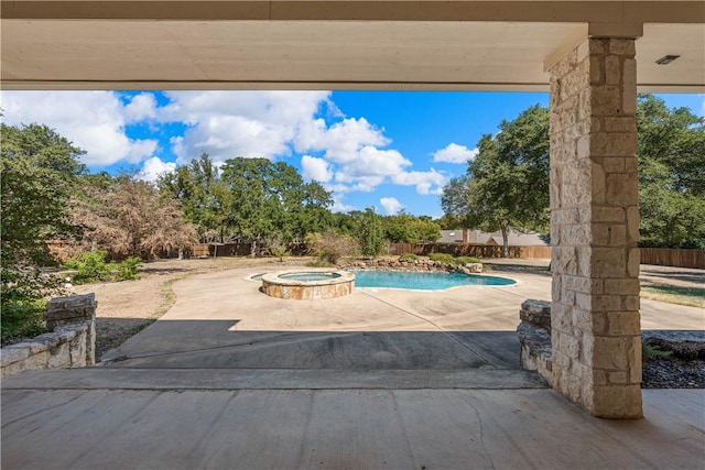 exterior space featuring an in ground hot tub and a patio area