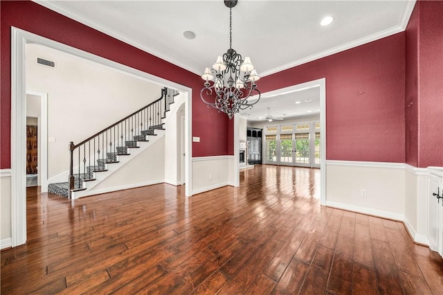 unfurnished dining area with crown molding, wood-type flooring, and ceiling fan with notable chandelier