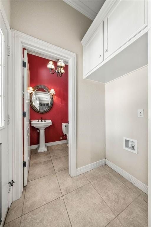 laundry room with sink, cabinets, a chandelier, light tile patterned floors, and ornamental molding