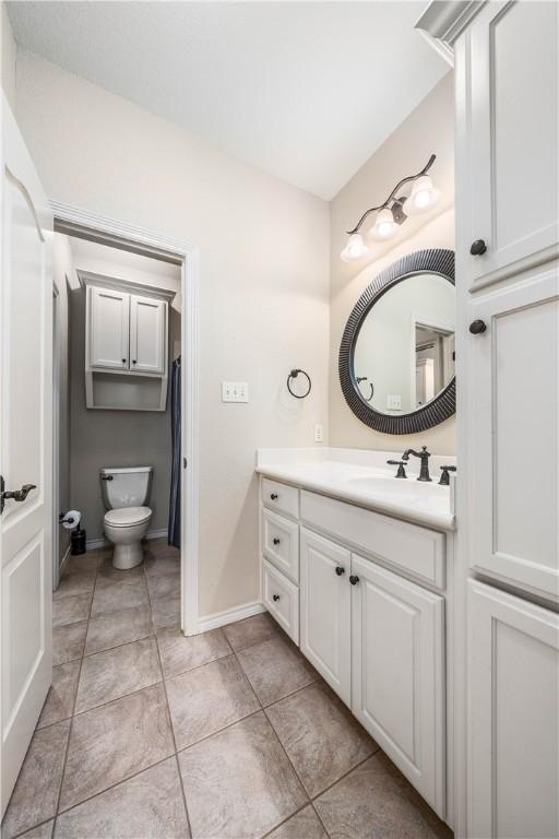 bathroom with tile patterned flooring, vanity, and toilet