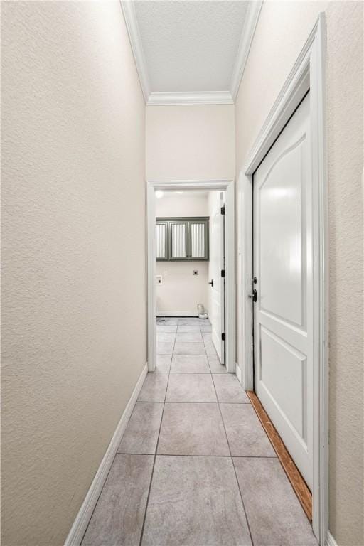 hall with light tile patterned floors and ornamental molding