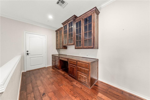 bar featuring built in desk, dark brown cabinets, dark hardwood / wood-style flooring, and ornamental molding