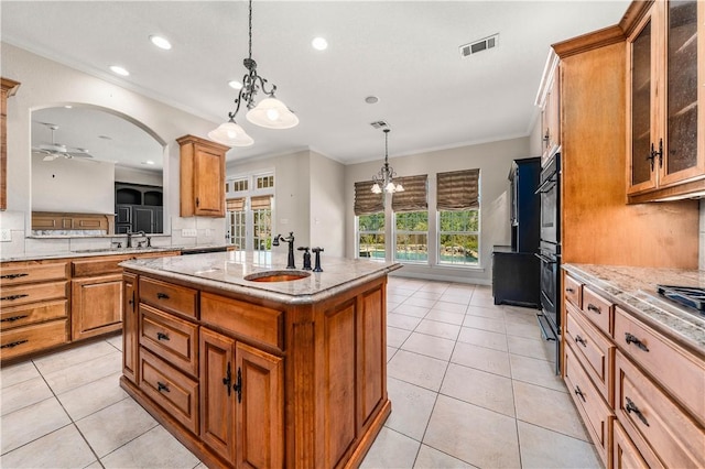 kitchen featuring a center island with sink, a wealth of natural light, ornamental molding, and sink