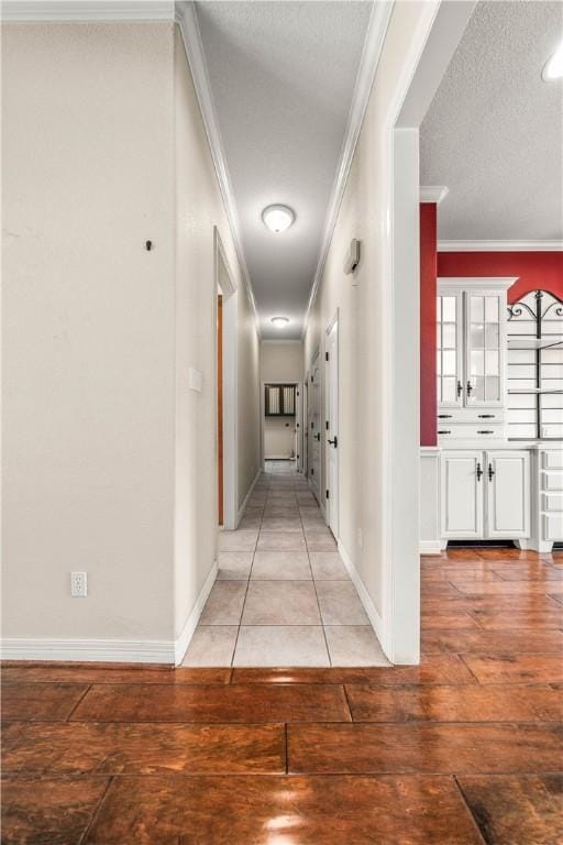 hallway featuring light hardwood / wood-style flooring, a textured ceiling, and ornamental molding