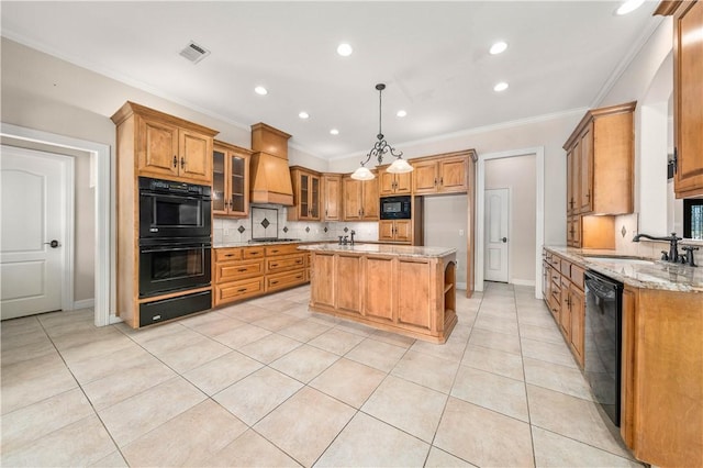 kitchen featuring premium range hood, black appliances, light stone countertops, an island with sink, and decorative light fixtures