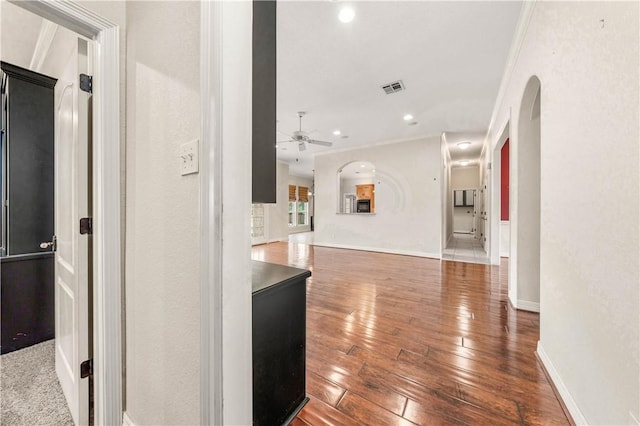 hallway with crown molding and hardwood / wood-style floors