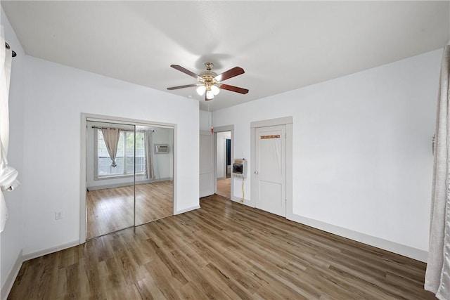 unfurnished bedroom featuring wood-type flooring, a closet, and ceiling fan