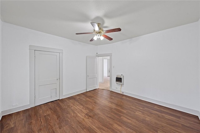 unfurnished bedroom with heating unit, ceiling fan, and dark wood-type flooring