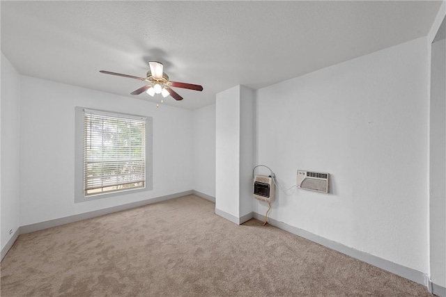 empty room with light carpet, a wall mounted air conditioner, heating unit, and ceiling fan